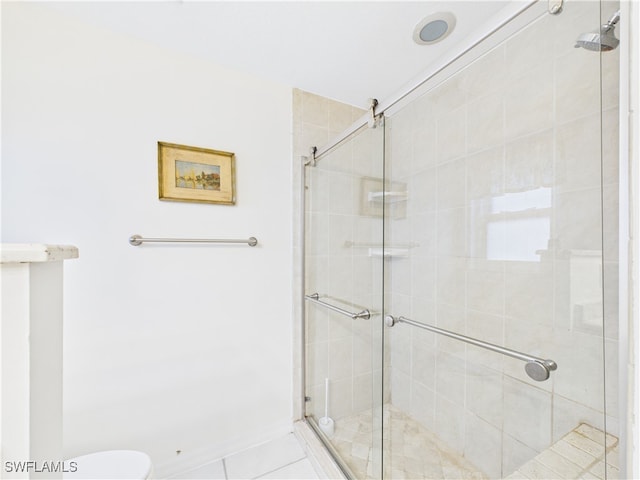 bathroom with a stall shower, baseboards, and toilet