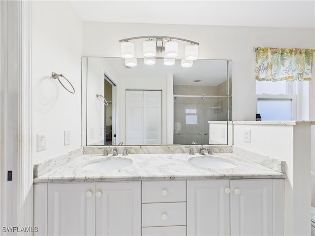 full bathroom featuring a sink, a shower stall, and double vanity