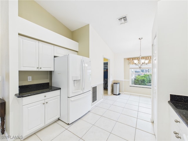 kitchen featuring light tile patterned flooring, white refrigerator with ice dispenser, visible vents, and white cabinets