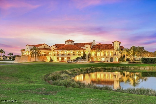 16445 Carrara Way Unit 201, Naples, FL 34110 - rear view of property featuring a lawn, a water view, and stucco siding