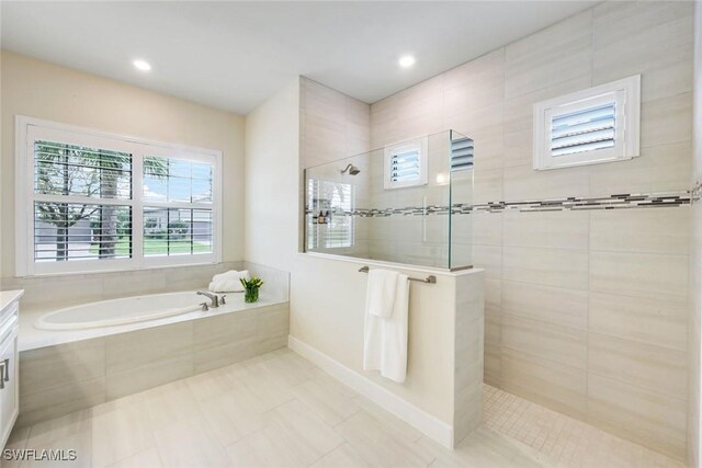 bathroom with a garden tub, recessed lighting, a walk in shower, and vanity