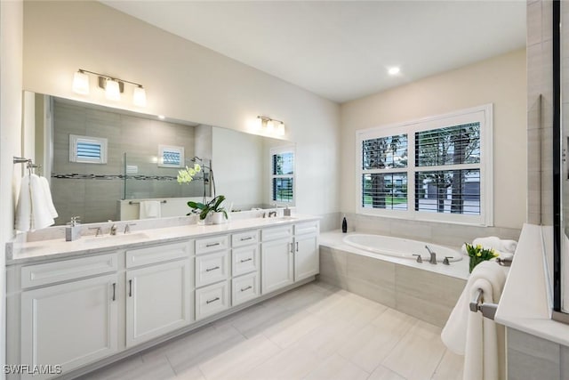 full bathroom featuring double vanity, a sink, a tile shower, and a bath