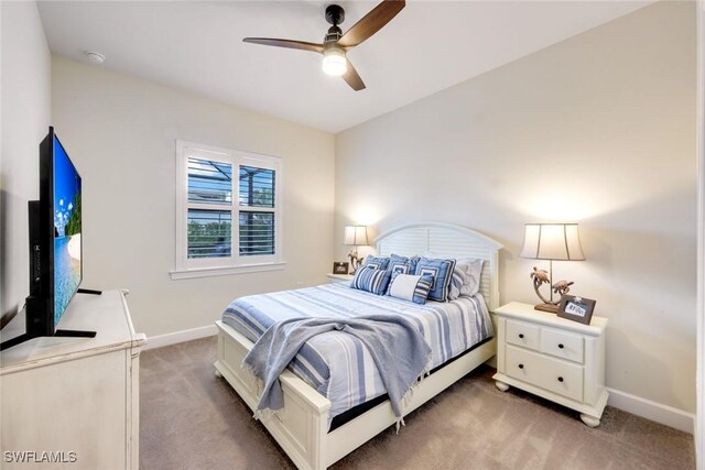 bedroom featuring light carpet, baseboards, and a ceiling fan