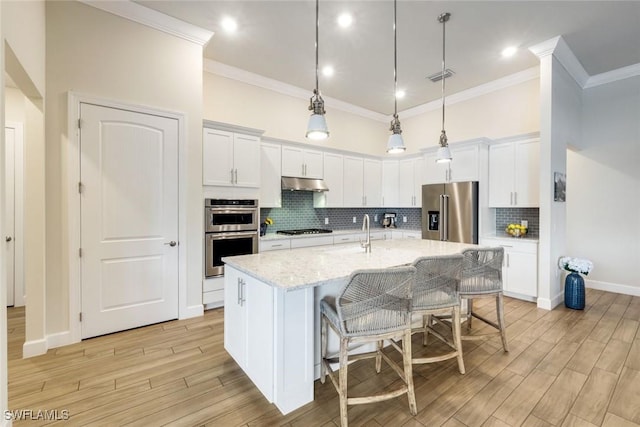 kitchen featuring stainless steel appliances, light wood-type flooring, white cabinetry, and under cabinet range hood