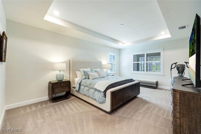 bedroom with light carpet, baseboards, visible vents, a raised ceiling, and recessed lighting