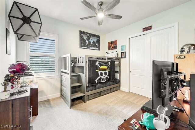 carpeted bedroom with ceiling fan and baseboards