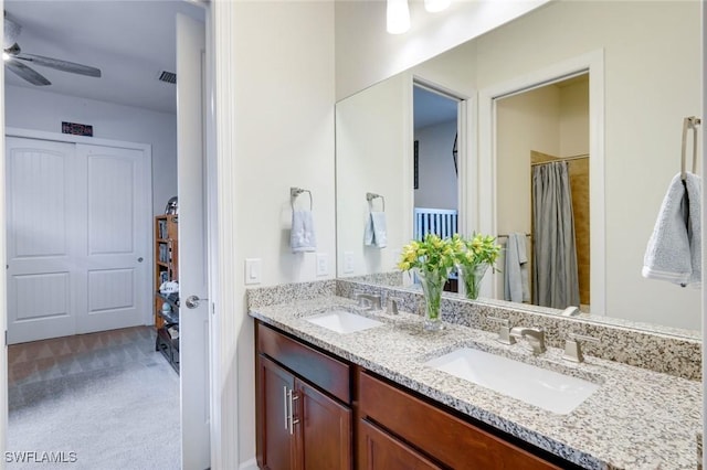 full bathroom featuring double vanity, a ceiling fan, and a sink