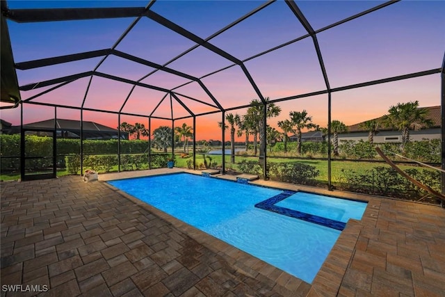 9151 Snowy Owl Way, Naples, FL 34120 - pool at dusk with a patio, glass enclosure, and a pool with connected hot tub