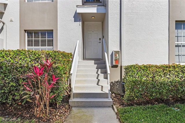 entrance to property featuring stucco siding