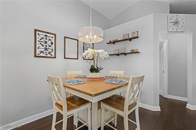 dining space with vaulted ceiling, baseboards, and wood finished floors