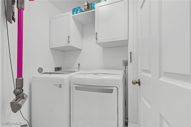 clothes washing area with independent washer and dryer and cabinet space