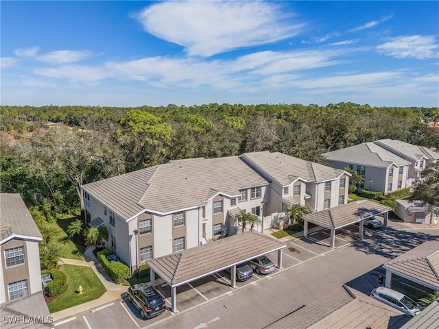 drone / aerial view featuring a residential view and a view of trees