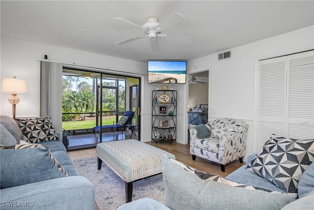 living room with visible vents, ceiling fan, and wood finished floors