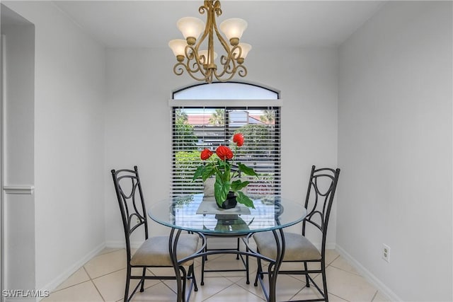 dining room with baseboards, light tile patterned floors, and an inviting chandelier