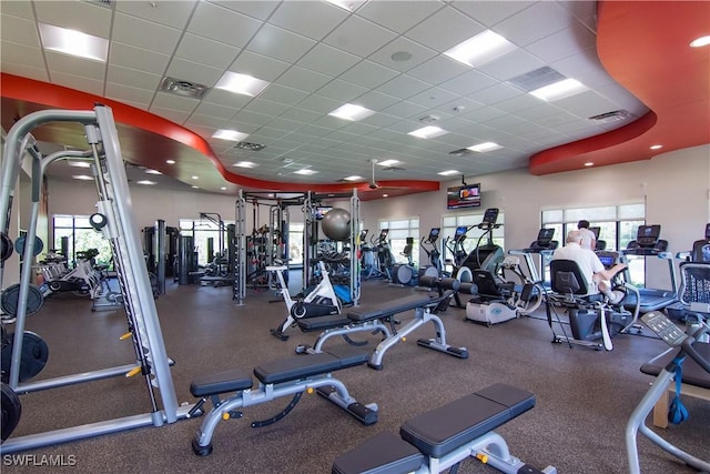 gym with visible vents, plenty of natural light, and a drop ceiling