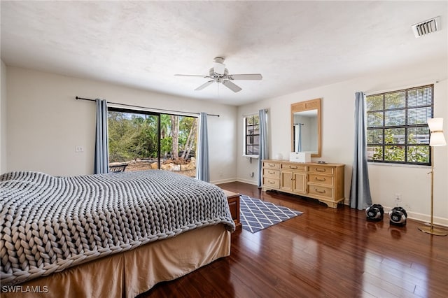 bedroom with multiple windows, wood finished floors, visible vents, and baseboards