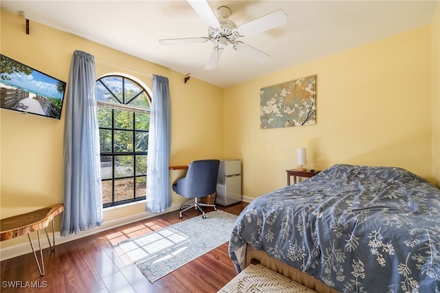 bedroom with ceiling fan, baseboards, and wood finished floors