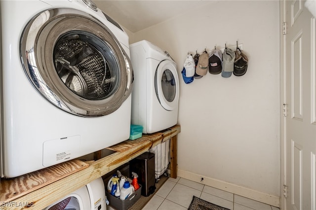 washroom featuring washer / dryer, baseboards, light tile patterned floors, and laundry area