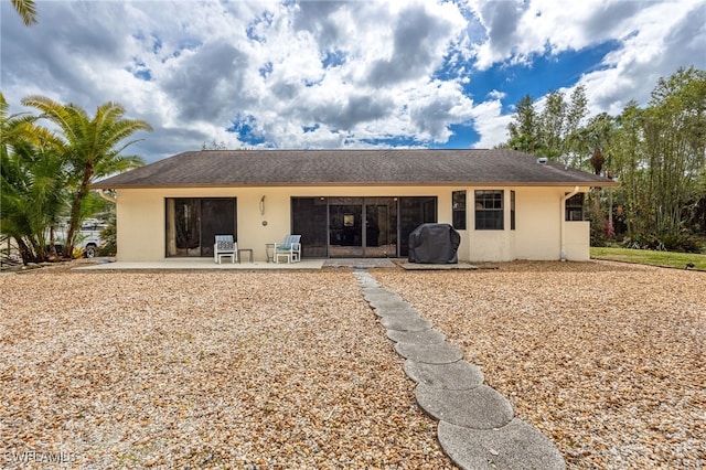 back of property with a patio area and stucco siding