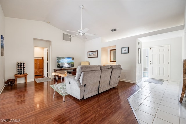 living room featuring visible vents, vaulted ceiling, and wood finished floors