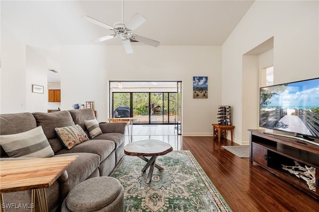 living room featuring dark wood-style floors, a ceiling fan, and baseboards