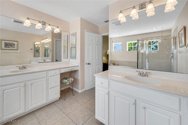 bathroom with visible vents, a sink, a shower stall, and tile patterned floors