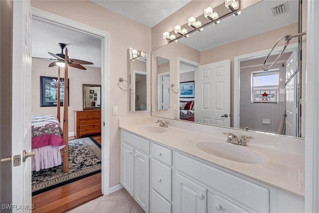 full bath with a sink, double vanity, visible vents, and connected bathroom