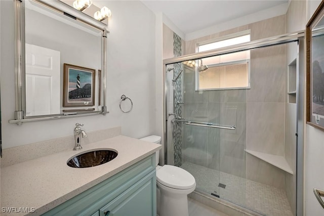 full bath featuring a stall shower, vanity, and toilet