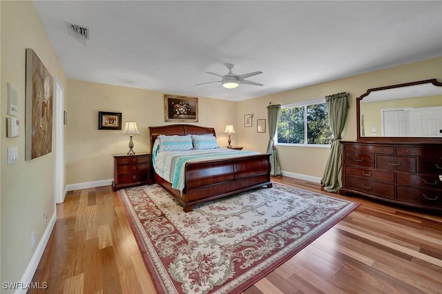 bedroom with visible vents, baseboards, and wood finished floors