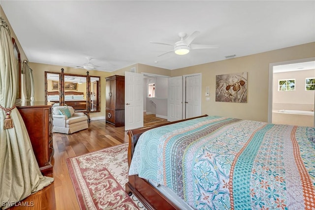 bedroom with ceiling fan, wood finished floors, visible vents, and baseboards