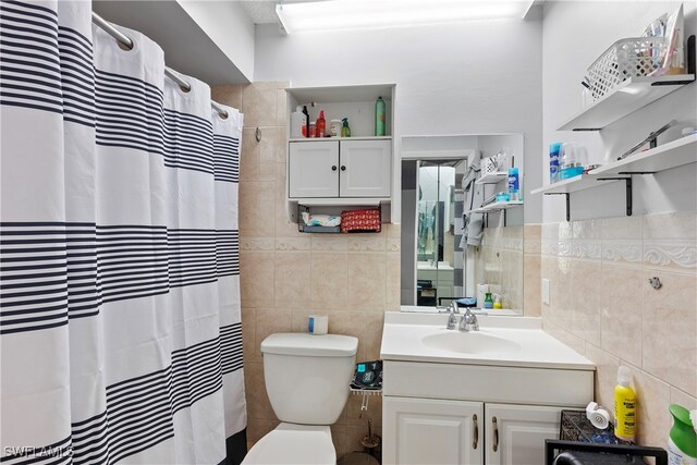 full bath featuring toilet, vanity, tile walls, and a shower with curtain