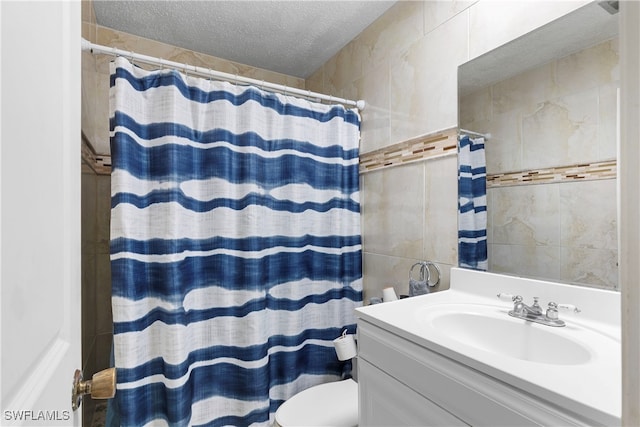 bathroom with a shower with curtain, toilet, a textured ceiling, and vanity