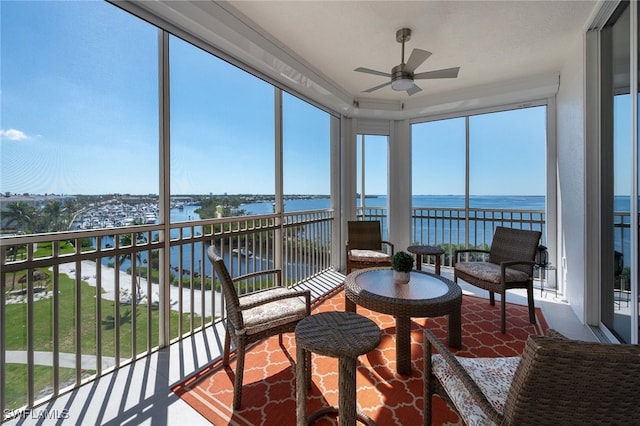 sunroom / solarium with a water view and ceiling fan