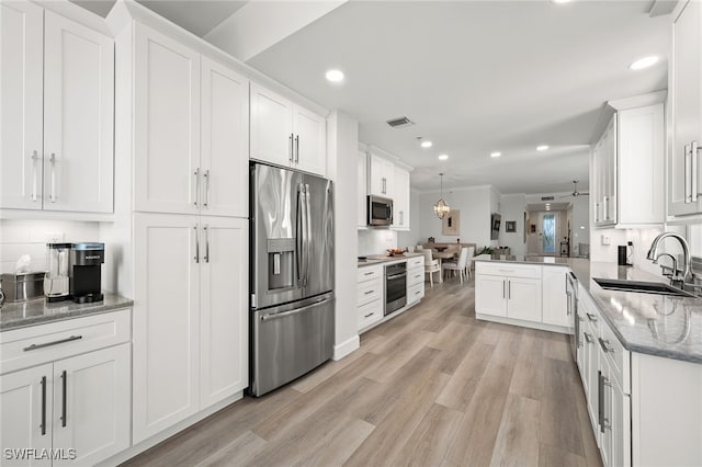 kitchen featuring stainless steel appliances, a sink, and white cabinets