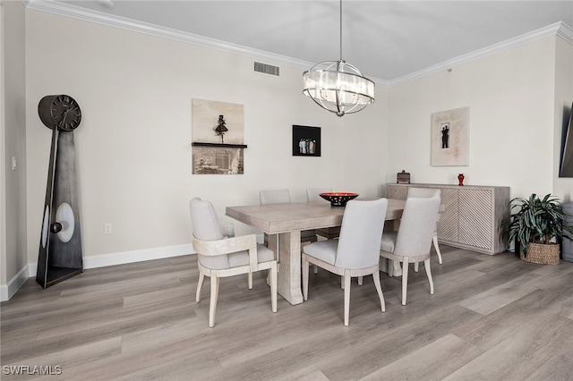 dining room with a notable chandelier, wood finished floors, visible vents, baseboards, and ornamental molding