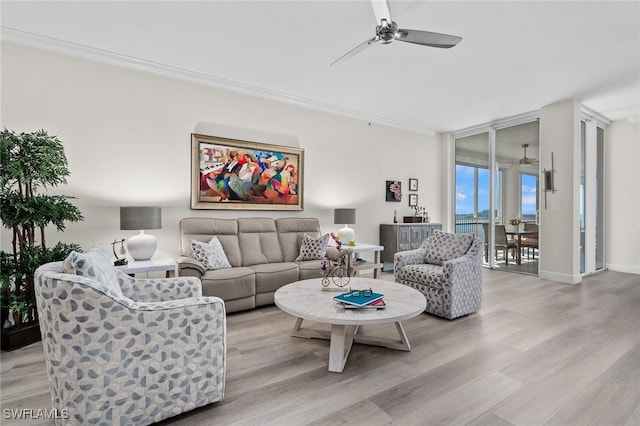 living area featuring ceiling fan, light wood-style floors, baseboards, floor to ceiling windows, and crown molding