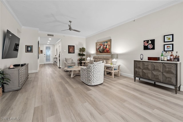 living area featuring ceiling fan, visible vents, baseboards, light wood-style floors, and ornamental molding