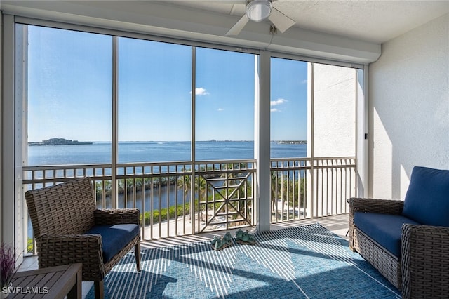 sunroom / solarium with a water view and a ceiling fan