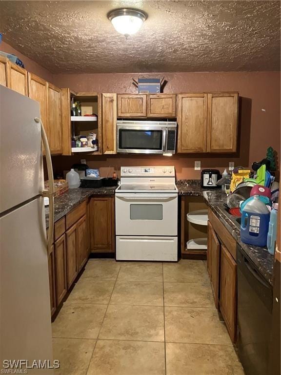 kitchen with brown cabinets, white appliances, light tile patterned floors, and open shelves