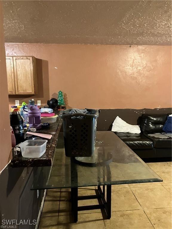 dining area with a textured ceiling and light tile patterned floors