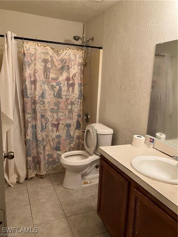 bathroom with a textured wall, a shower with shower curtain, toilet, vanity, and tile patterned flooring