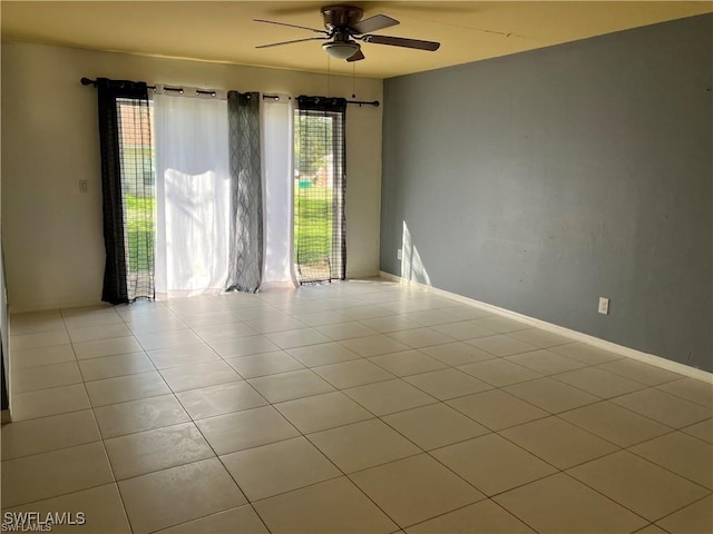 spare room featuring ceiling fan, baseboards, and tile patterned floors