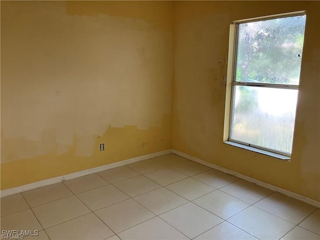 spare room with light tile patterned flooring and baseboards