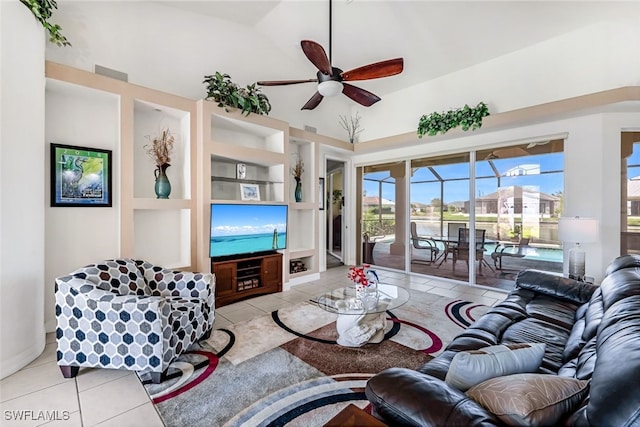 tiled living area with a sunroom, built in features, and a ceiling fan