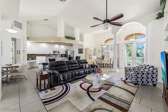 living area featuring high vaulted ceiling, french doors, light tile patterned flooring, and visible vents