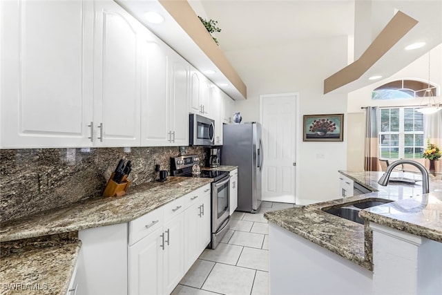 kitchen with light tile patterned floors, decorative backsplash, appliances with stainless steel finishes, vaulted ceiling, and a sink