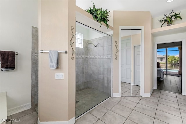 bathroom featuring tile patterned flooring, baseboards, and walk in shower