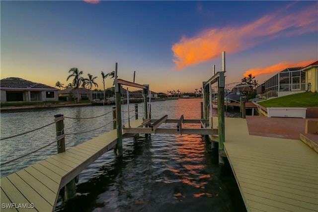 view of dock featuring a water view, boat lift, and a residential view