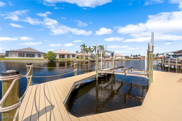 view of dock with a water view, boat lift, and a residential view