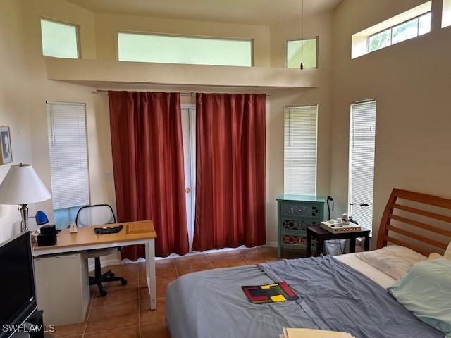 bedroom with a towering ceiling and tile patterned floors